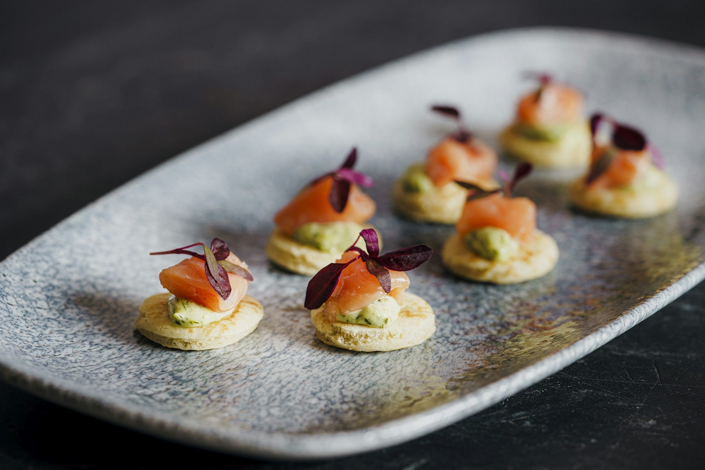 A tray of canapes and small bites arranged for passing at a catered reception.